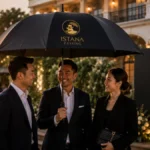 Payung golf hitam premium dengan logo Istana Payung di event anniversary perusahaan outdoor